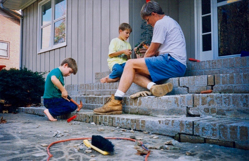 A young Ryan with his brother and Dad, David Kinney, remodeling brick steps.